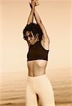 Woman Standing on Beach with Arms Raised