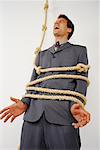 Homme d'affaires attachée avec une corde nouée, criant