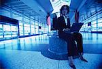 Businesswoman Using Laptop in Terminal