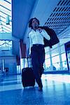 Businesswoman Walking in Terminal Pulling Luggage