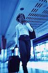 Businesswoman Walking in Terminal Pulling Luggage