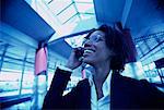 Businesswoman Using Cell Phone Laughing in Terminal