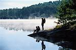 Couple on Rocks near Lake with Fog, Haliburton, Ontario, Canada