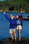 Portrait de Couple avec équipement de randonnée, debout sur les rochers près de Haliburton Lake, Ontario, Canada