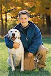 Portrait de garçon avec chien à l'extérieur en automne