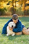Junge im Feld mit Hund im Herbst