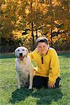 Portrait de garçon avec chien sur le terrain à l'automne