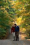 Couple marchant sur le chemin à travers les arbres en automne Caledon, Ontario, Canada