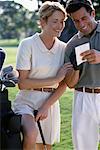Couple on Golf Course, Looking At Score Card
