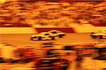 Blurred View of Race Cars and Crowd