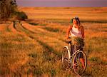 Femme marchant dans le champ avec le vélo, Alberta, Canada