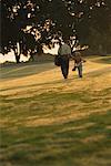Back View of Father and Son Walking on Golf Course