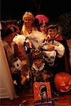 Group Portrait of Children Standing in Doorway Wearing Halloween Costumes