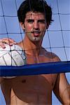 Porträt des Mannes stützte sich auf Net halten Volleyball im freien