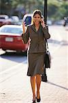 Businesswoman Walking on Street Using Cell Phone