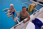 Porträt von Reife Paar in Badebekleidung mit Trainingsgeräten im Schwimmbad