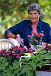 Portrait of Mature Woman in Garden with Impatience and Zinnia Flowers