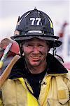 Portrait of Male Firefighter Holding Axe Outdoors