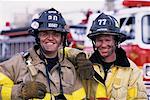 Portrait of Two Male Firefighters Standing near Fire Engine