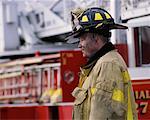 Mature Male Firefighter Standing Near Fire Truck