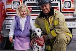 Portrait of Mature Male Firefighter, Girl and Dalmatian By Fire Truck