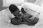 Bride and Groom Lying on Bed Holding Hands