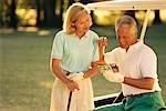 Mature Couple on Golf Course With Golf Cart