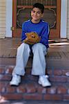 Portrait of Boy Sitting on Porch With Baseball Glove