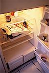 Sparsely Stocked Fridge with Pizza Box