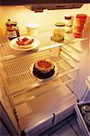 Sparsely Stocked Fridge with Cake and Pastry