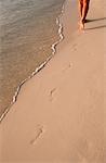 Frau zu Fuß am Strand, so dass Footprints