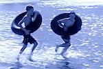 Two Boys in Swimwear, Playing With Inner Tubes in Water