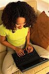 Portrait of Woman Sitting on Sofa Using Laptop Computer