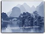 Mann sitzt auf den Felsen in der Yulong-River Dragon Bridge in der Nähe von Yangshuo, Gebiet Guangxi, China