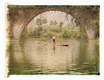 Man in Raft on Yulong River near Dragon Bridge, near Yangshuo Guangxi Region, China