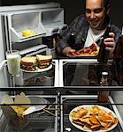 Mann, Pizza und Bier aus dem Kühlschrank nehmen
