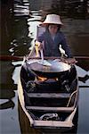 Woman Preparing Food in Vendor Boat in Floating Market Bangkok, Thailand