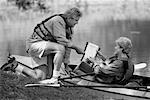 Mature Couple Reading Map on Shore with Kayak