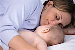 Mother and Baby Lying on Bed Sleeping