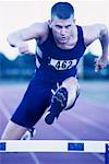 Male Athlete Jumping Hurdles