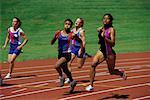 Jeunes femmes en cours d'exécution sur la piste de course