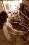 Femme debout au réfrigérateur, ayant Pie comme collation de minuit