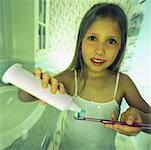 Portrait de jeune fille dans la salle d'eau mettre le dentifrice sur la brosse à dents