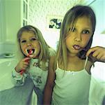 Portrait de deux jeunes filles se brosser les dents dans les toilettes