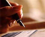 Close-Up of Woman's Hand Holding Pen, Signing Document