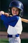 Porträt eines jungen tragen Baseball Uniform und Helme, Bat Holding