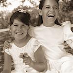 Portrait of Two Girls Wearing Dresses, Holding Toy Butterfly Outdoors