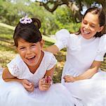Two Girls Wearing Dresses Playing with Toy Butterfly Outdoors