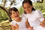 Deux jeunes filles portant des robes en riant à l'extérieur