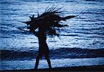 Silhouette of Person Carrying Leaves on Beach Amed, Bali, Indonesia